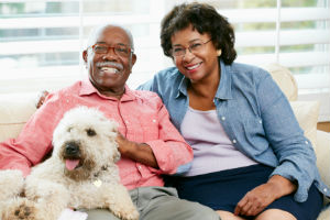 Happy Senior Couple Sitting With Their Dog